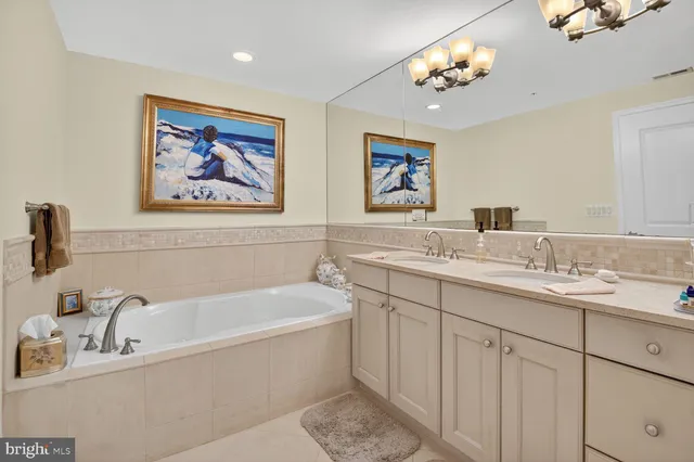 a bathroom with a double vanity sink a bathtub a mirror and vanity