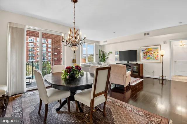 a dining room with furniture potted plants and wooden floor