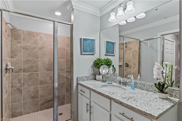 a bathroom with a granite countertop sink a mirror and a shower