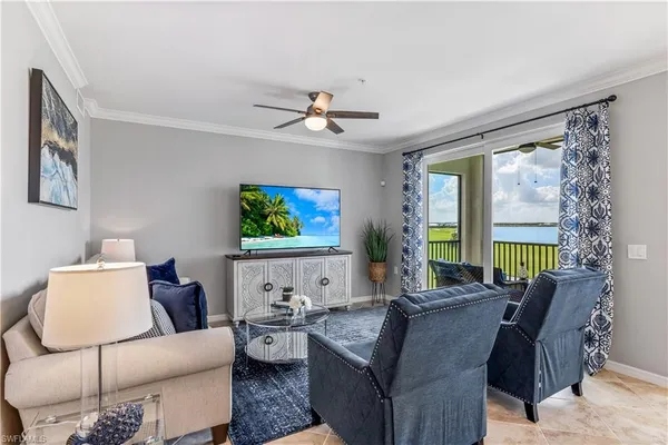 a living room with furniture a large window and a flat screen tv