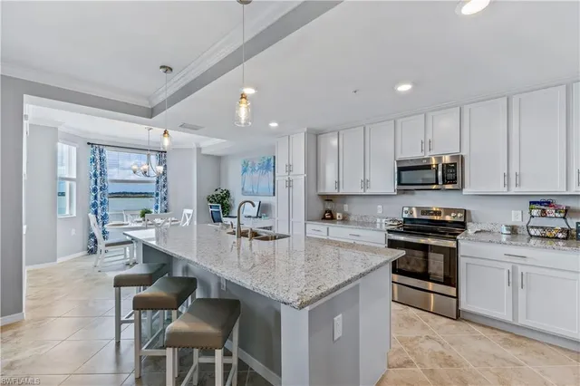 a kitchen with stainless steel appliances granite countertop a stove top oven a sink dishwasher a dining table and chairs with wooden floor