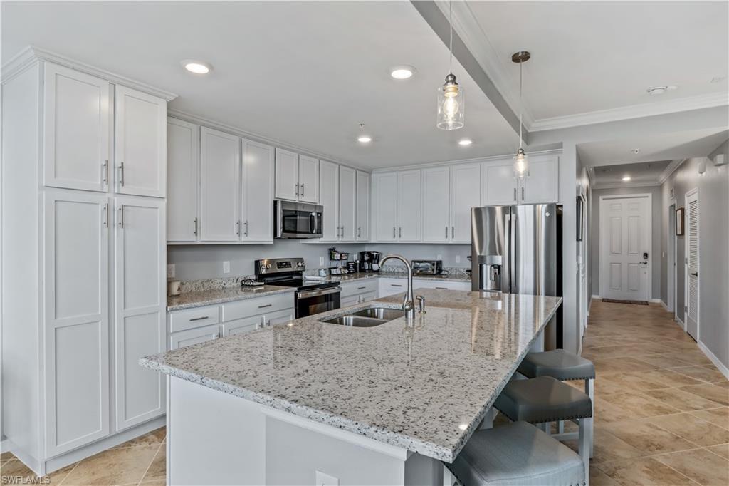 43020 Greenway Boulevard, Unit 332 Babcock Ranch, FL 33982 - Photo 6 of 13 a kitchen with stainless steel appliances granite countertop a sink refrigerator and cabinets