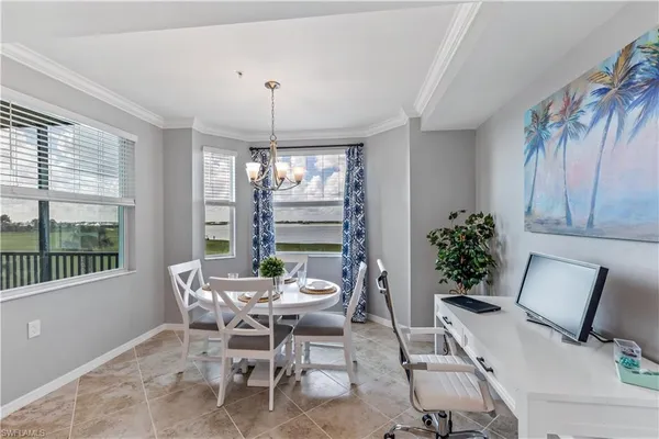a dining room with furniture a chandelier and window