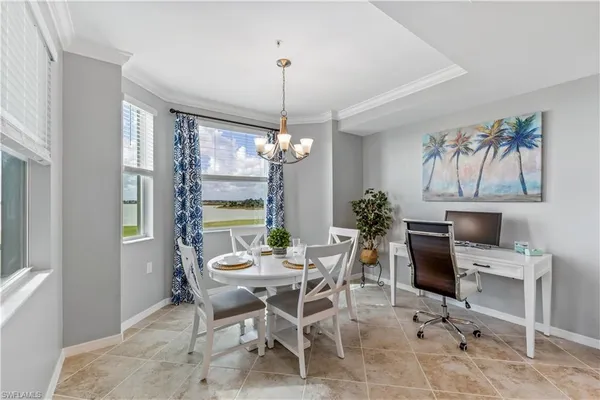 a dining room with furniture a chandelier and window