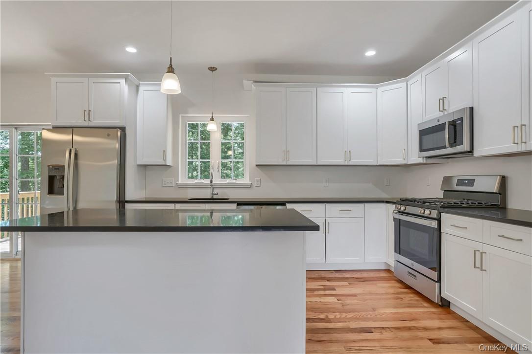 Lot 14-31 Sawyer Way Wallkill, NY 12589 - Photo 11 of 31 a kitchen with stainless steel appliances granite countertop a stove a sink and a microwave
