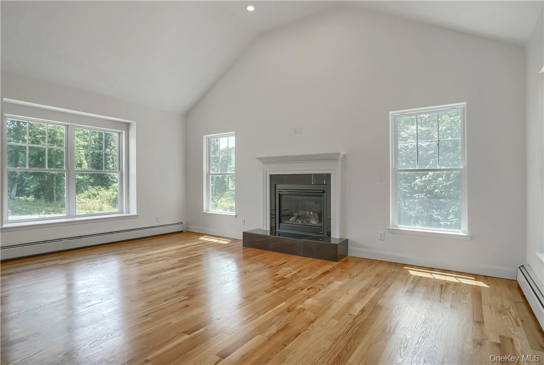 Lot 14-31 Sawyer Way Wallkill, NY 12589 - Photo 5 of 31 an empty room with wooden floor fireplace and windows