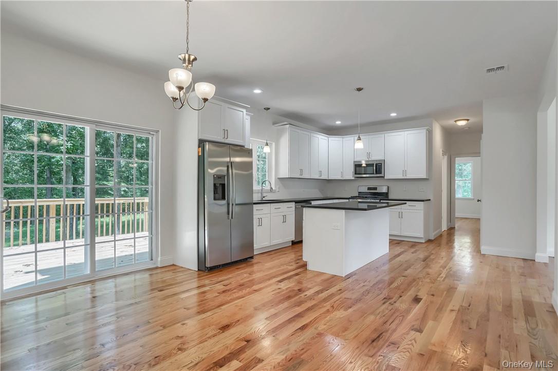 Lot 14-31 Sawyer Way Wallkill, NY 12589 - Photo 7 of 31 a view of kitchen with granite countertop stainless steel appliances cabinets a wooden floor and a large window