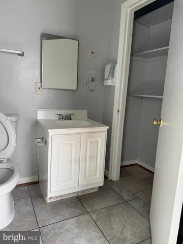 a utility room with a sink a toilet and a mirror
