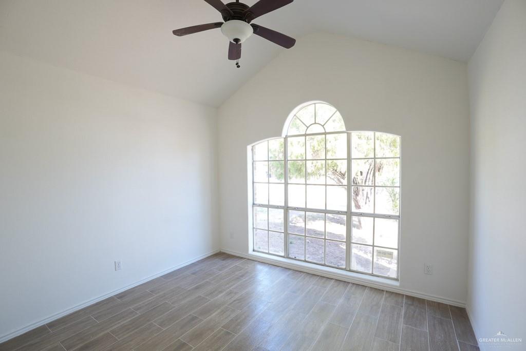 1602 East Rabbit Run Avenue Alton, TX 78573 - Photo 12 of 18 an empty room with wooden floor fan and windows