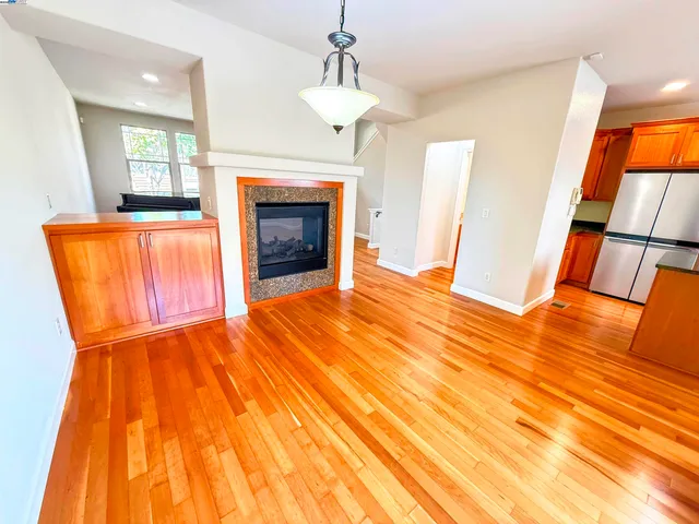 a view of open kitchen with wooden floor and stainless steel appliances