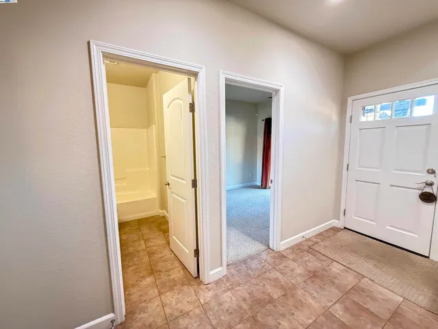 an empty room with mirror and a bathroom
