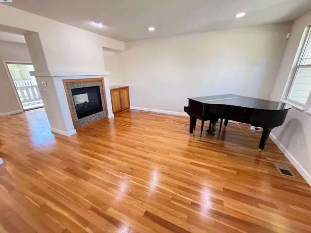 an empty room with wooden floor and fireplace