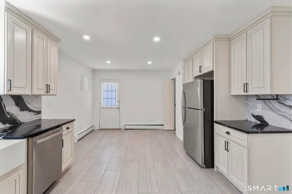 a kitchen with a refrigerator and a stove top oven