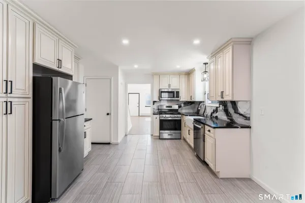 a kitchen with stainless steel appliances a refrigerator and a stove top oven