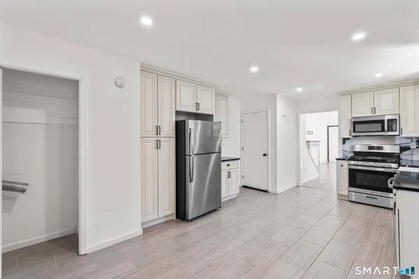 a kitchen with stainless steel appliances a refrigerator and a stove top oven