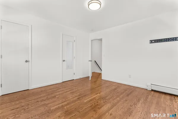 a view of empty room with wooden floor