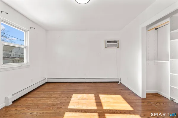a view of a room with wooden floor and white walls