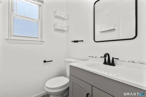 a bathroom with a toilet sink and mirror