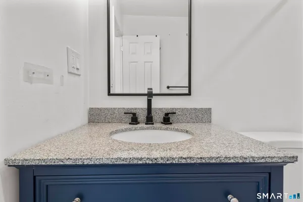 a bathroom with a granite countertop sink and a mirror