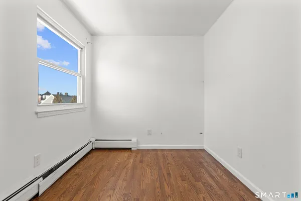 a view of a room with wooden floor and window