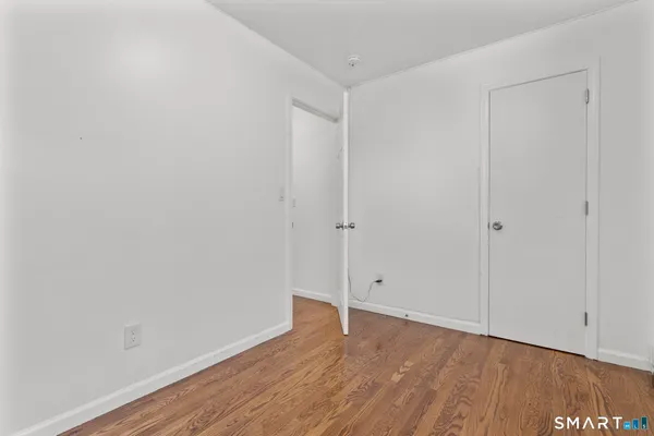 a view of an empty room with wooden floor