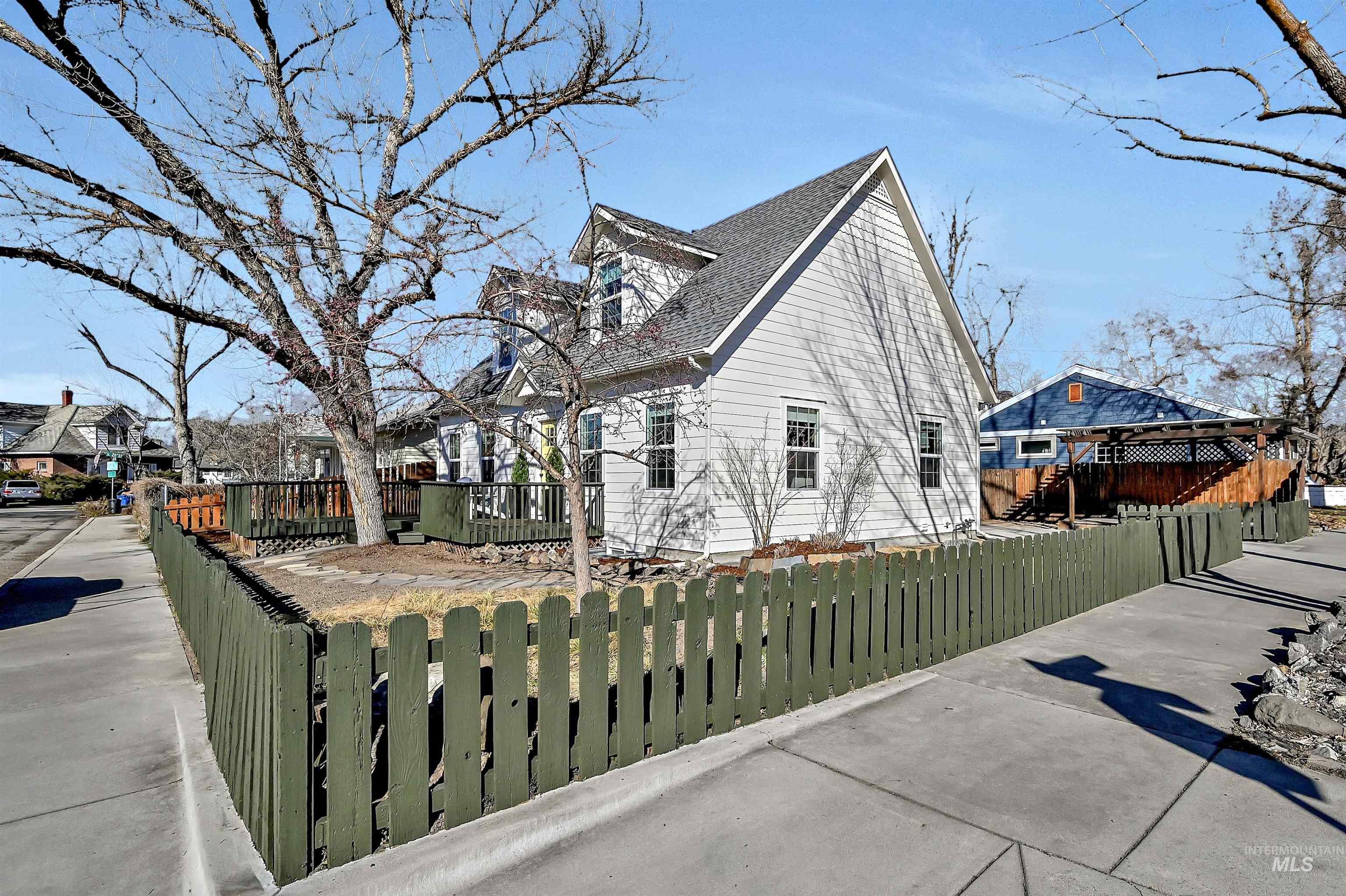 View of property exterior featuring a fenced front yard, a residential view, and roof with shingles