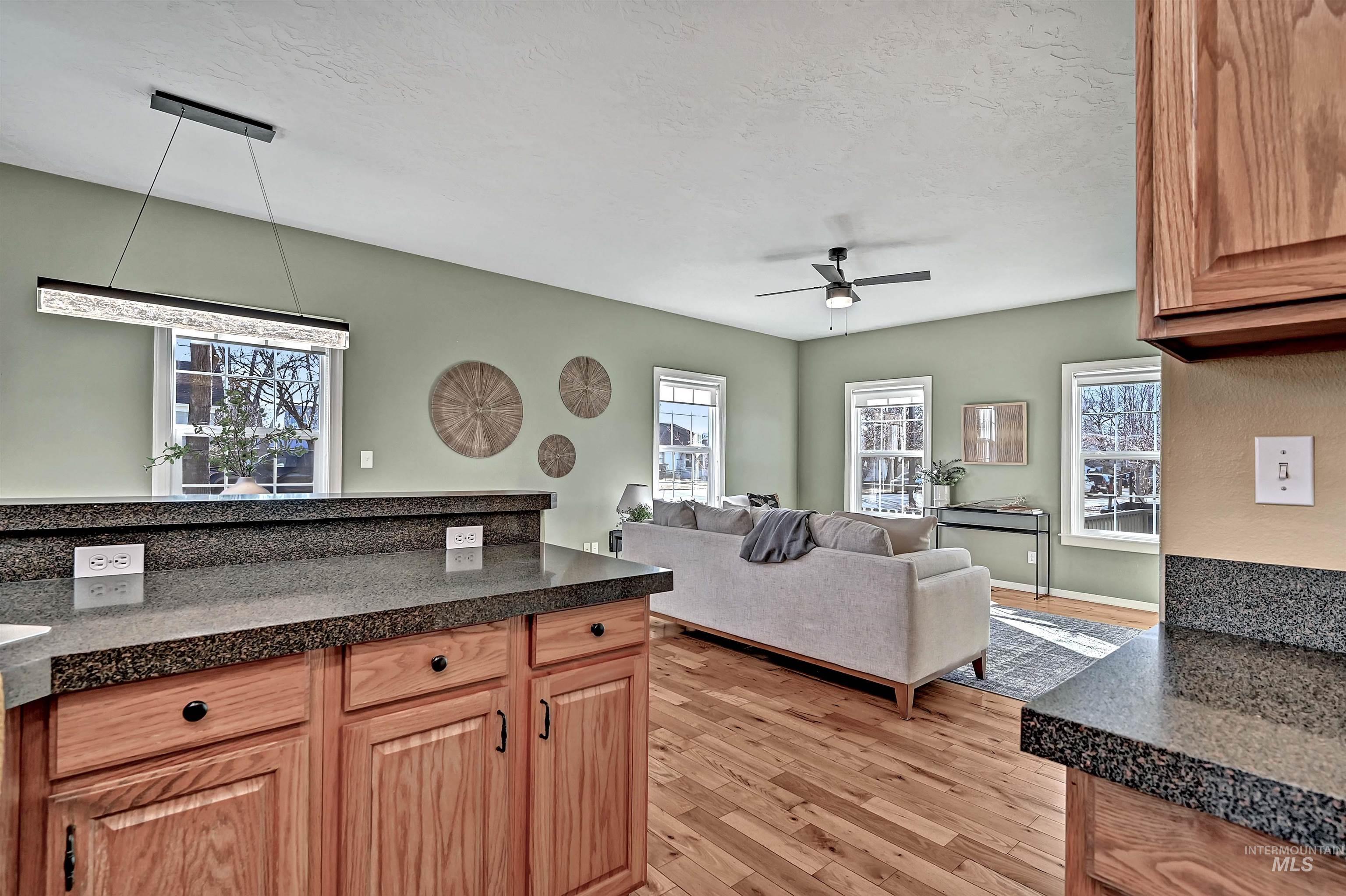 1902 West Washington Street Boise, ID 83702 - Photo 11 of 43 Kitchen featuring light wood-type flooring, pendant lighting, ceiling fan, healthy amount of natural light, and a textured ceiling