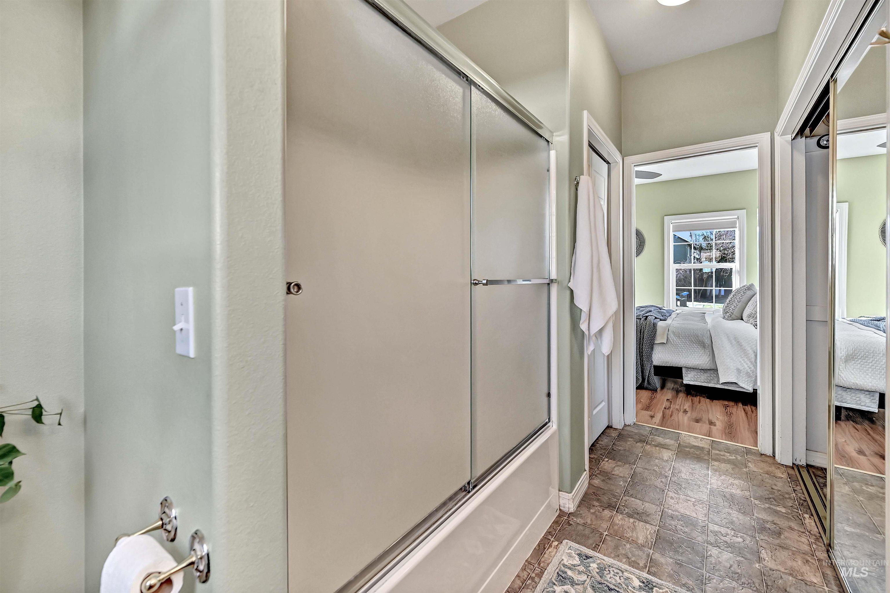 1902 West Washington Street Boise, ID 83702 - Photo 17 of 43 Bathroom with stone finish floors, ensuite bathroom, and bath / shower combo with glass door