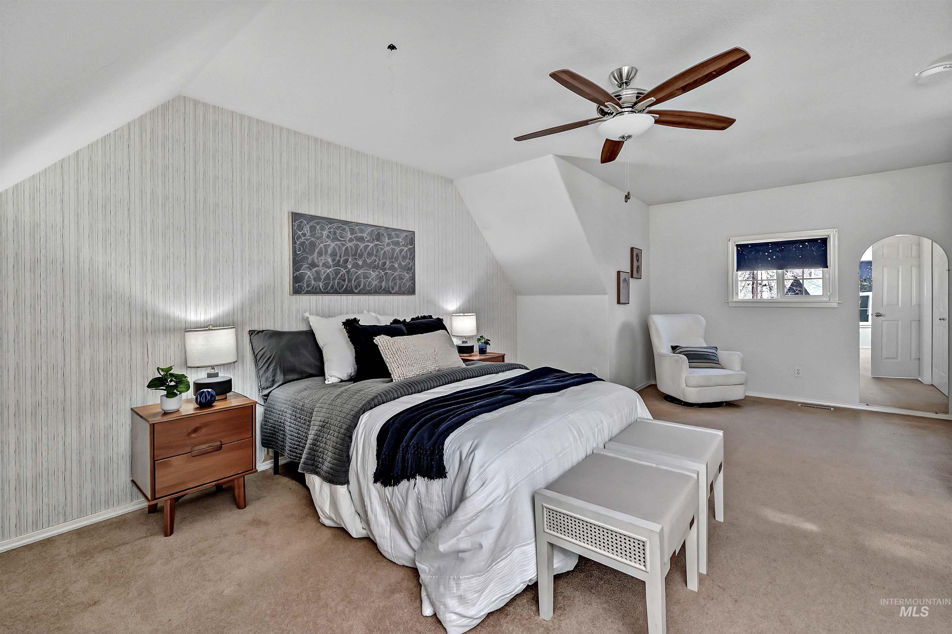1902 West Washington Street Boise, ID 83702 - Photo 21 of 43 Bedroom with wallpapered walls, vaulted ceiling, arched walkways, ceiling fan, and light carpet
