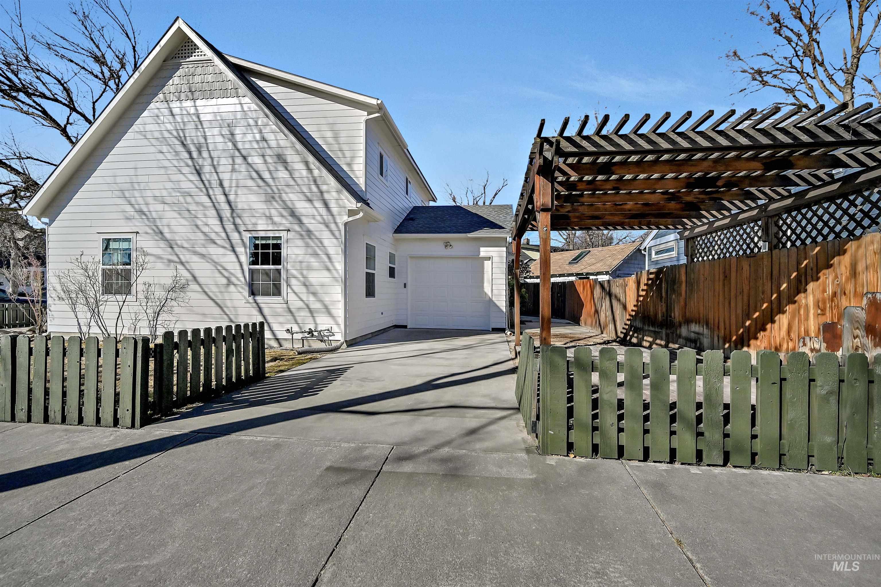 1902 West Washington Street Boise, ID 83702 - Photo 33 of 43 View of property exterior featuring a fenced front yard, driveway, an attached garage, and a pergola