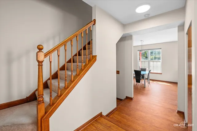 a view of staircase with lots of frames on wall and a window