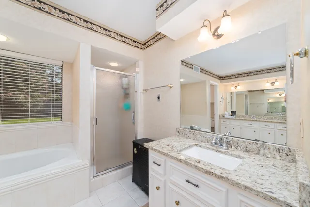 a bathroom with a granite countertop sink mirror and a bath tub