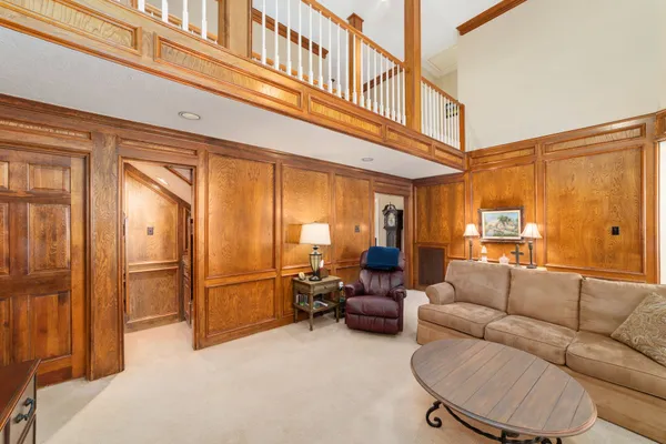 a living room with furniture a large window and stainless steel appliances