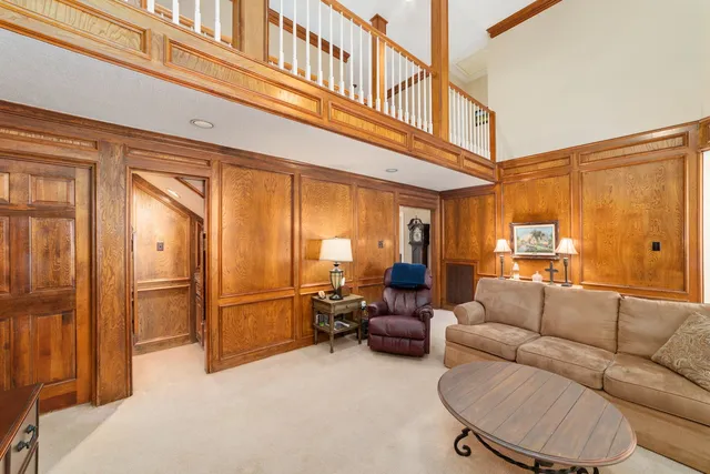 a living room with furniture a large window and stainless steel appliances