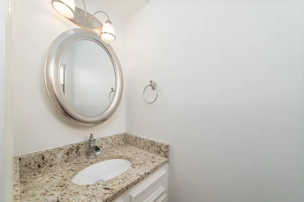 a bathroom with a granite countertop sink and a mirror
