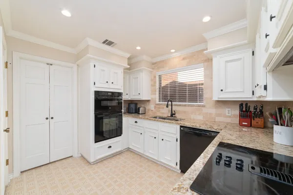 a kitchen with stainless steel appliances granite countertop a stove sink and cabinets