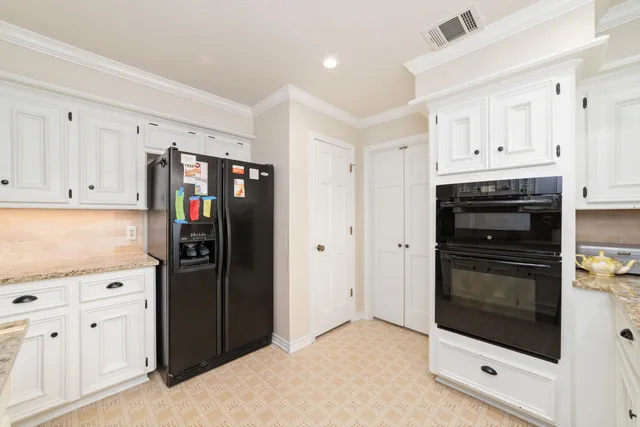 a kitchen with stainless steel appliances granite countertop a refrigerator and a stove top oven