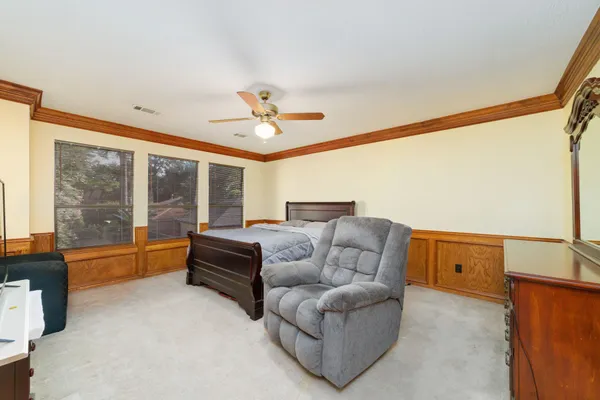 a bedroom with furniture and large windows