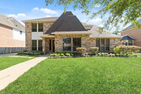 a front view of house with yard and green space