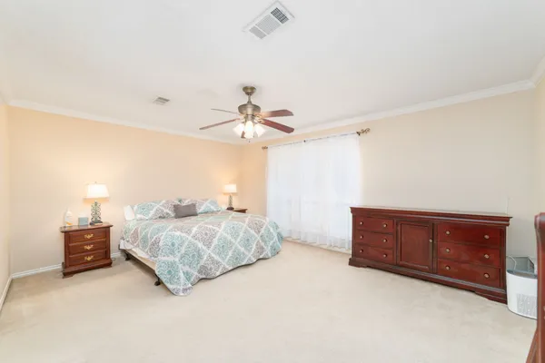 a bedroom with a bed dresser and a chandelier