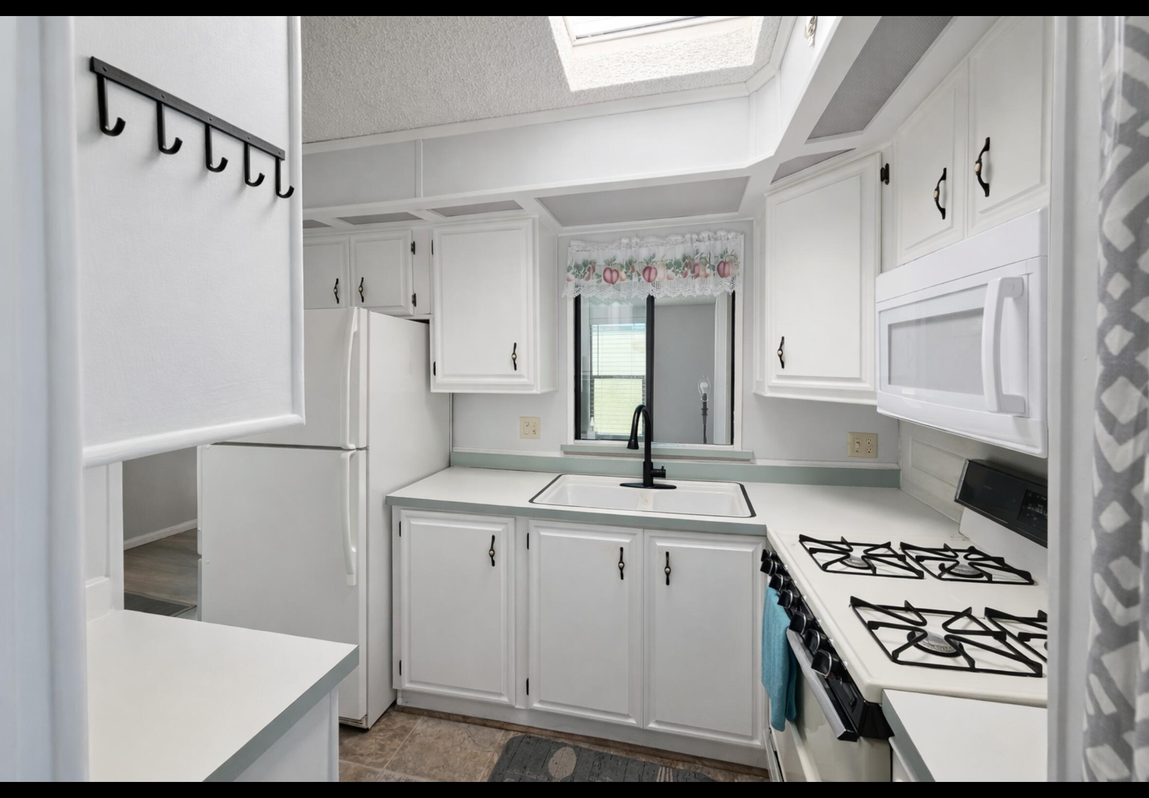 16400 Bubbling Wells Road, Unit 95 Desert Hot Springs, CA 92240 - Photo 5 of 21 a kitchen with cabinets and a stove