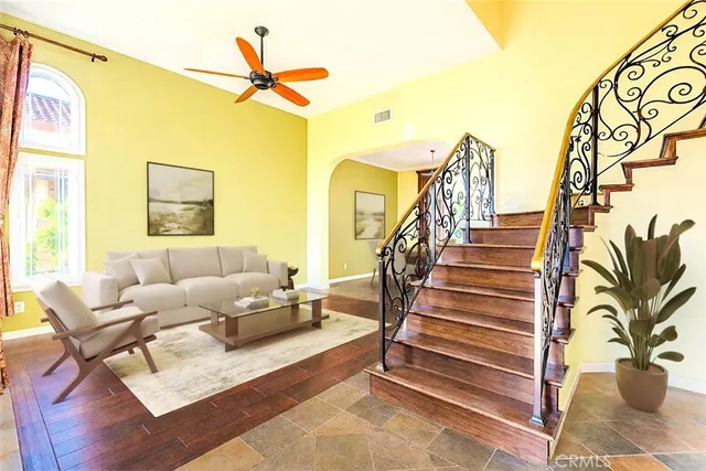 a living room with couches and a dining table with wooden floor