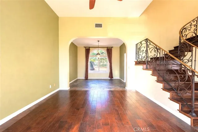 a hallway with wooden floor windows and a chandelier