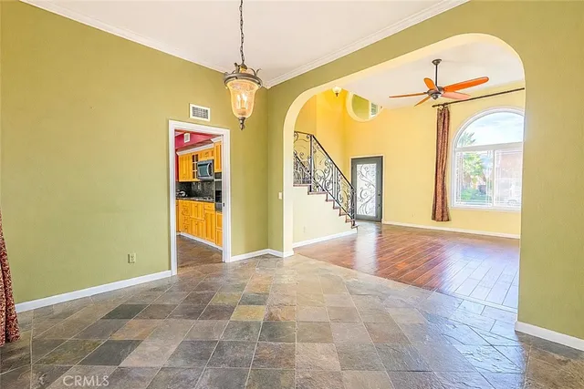 a view of a hallway with wooden floor and a chandelier