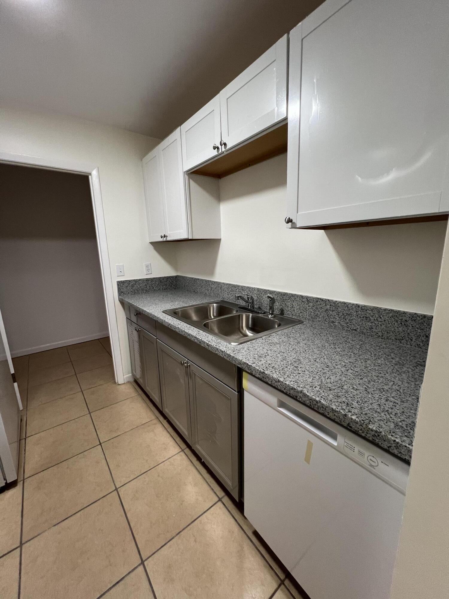 17345 Bush Road, Unit D Jupiter, FL 33458 - Photo 12 of 27 a kitchen with granite countertop a sink and a stove top oven