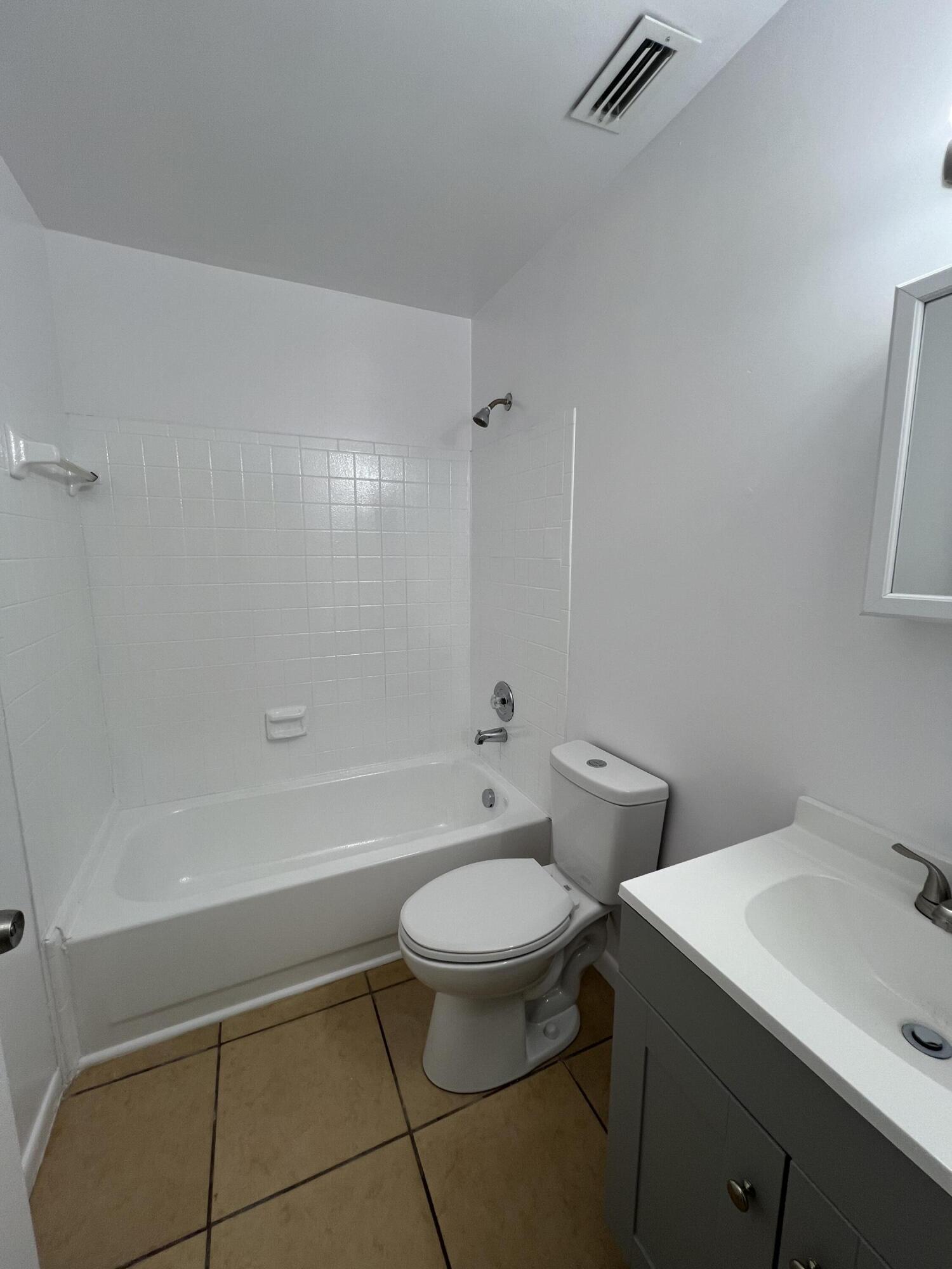 17345 Bush Road, Unit D Jupiter, FL 33458 - Photo 21 of 27 a bathroom with a sink a toilet and a bathtub
