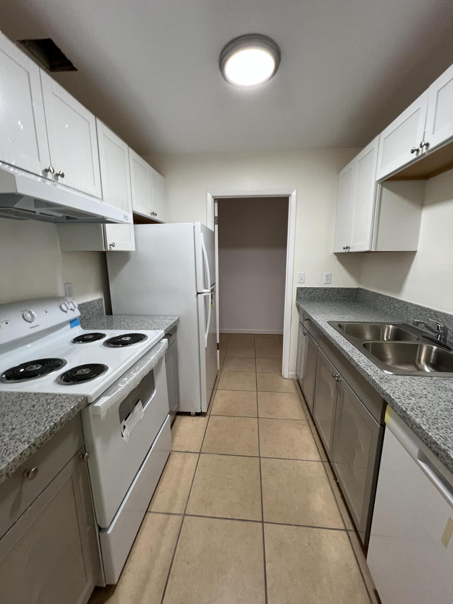 17345 Bush Road, Unit D Jupiter, FL 33458 - Photo 10 of 27 a kitchen with a stove top oven and cabinets