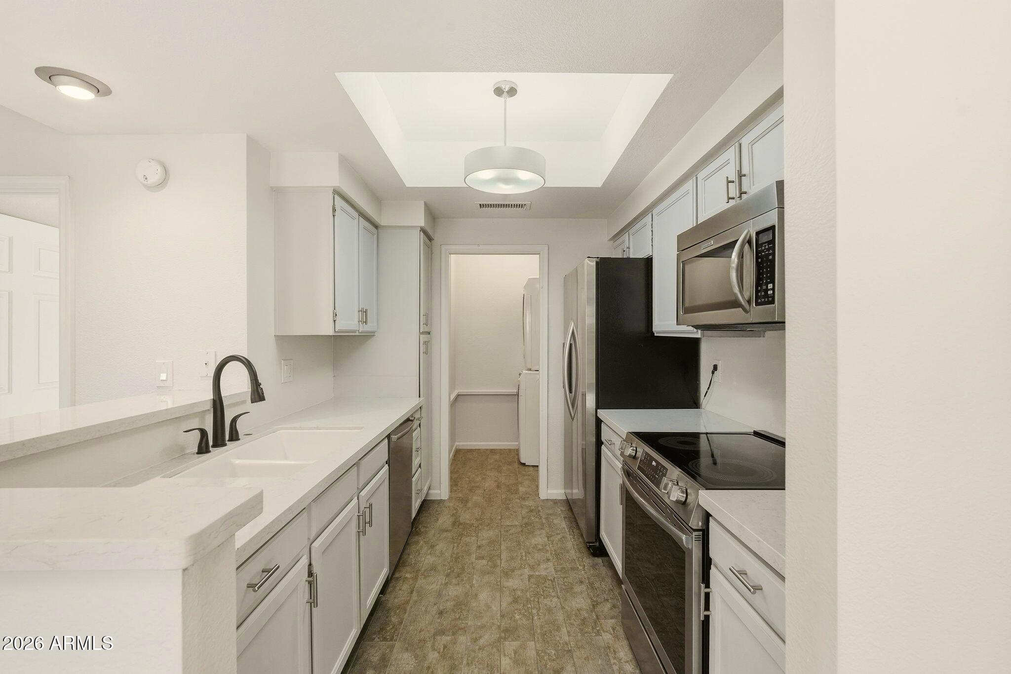 5640 East Bell Road Scottsdale, AZ 85254 - Photo 11 of 26 a kitchen with a sink stainless steel appliances and cabinets