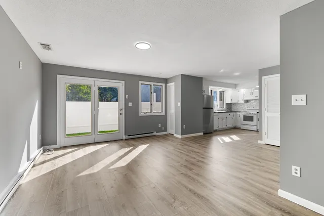 a view of a big room with wooden floor and windows