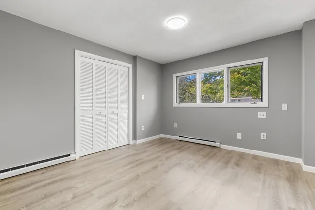 an empty room with windows and closet